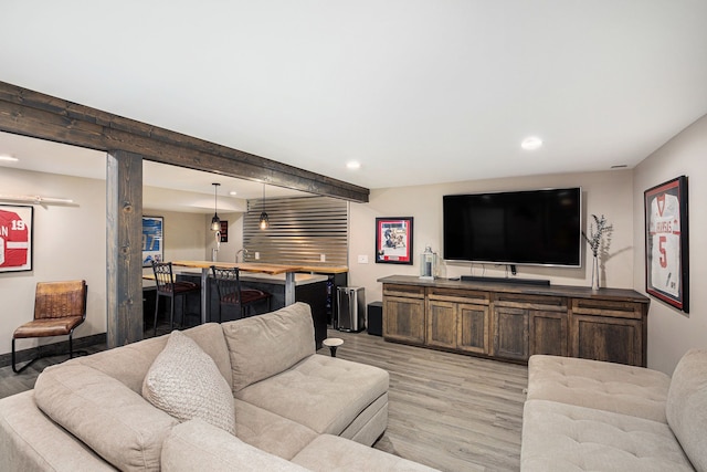 living room featuring beamed ceiling, indoor bar, and light hardwood / wood-style floors