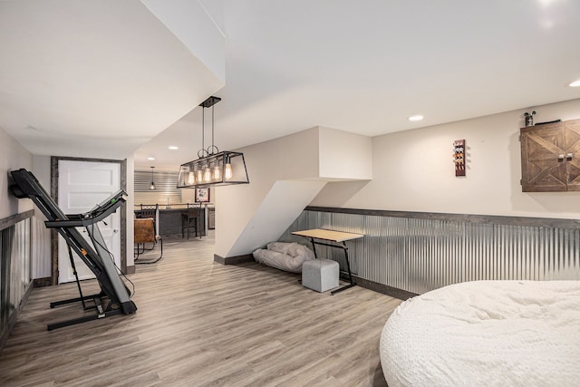 bedroom featuring indoor bar and light hardwood / wood-style floors