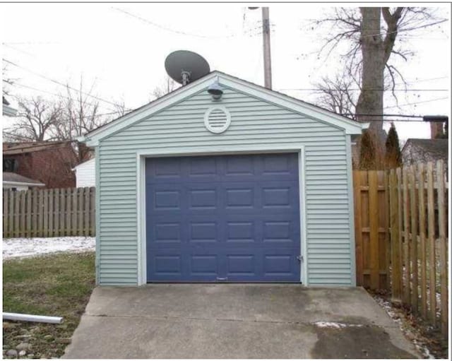 detached garage with driveway and fence