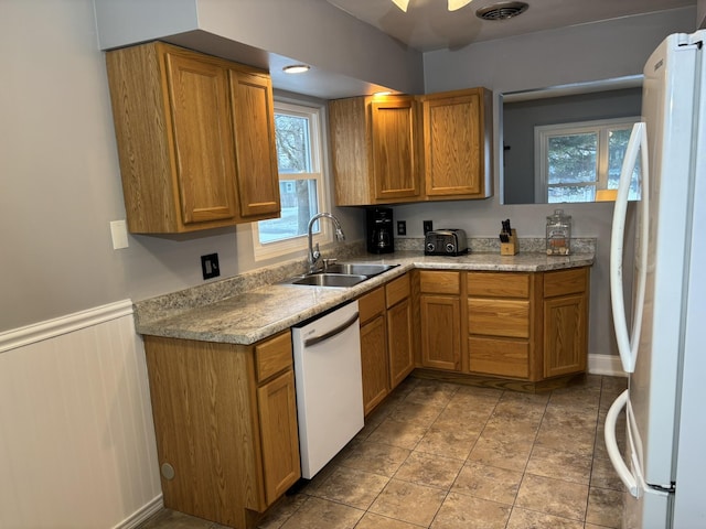 kitchen featuring white appliances, sink, and light tile patterned floors