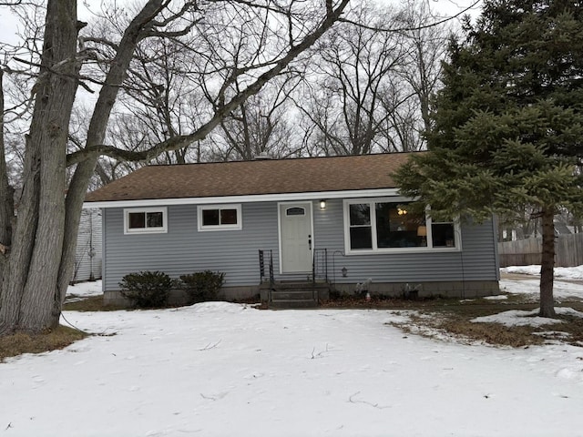 ranch-style house featuring roof with shingles