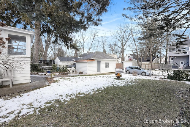 yard layered in snow with an outdoor structure