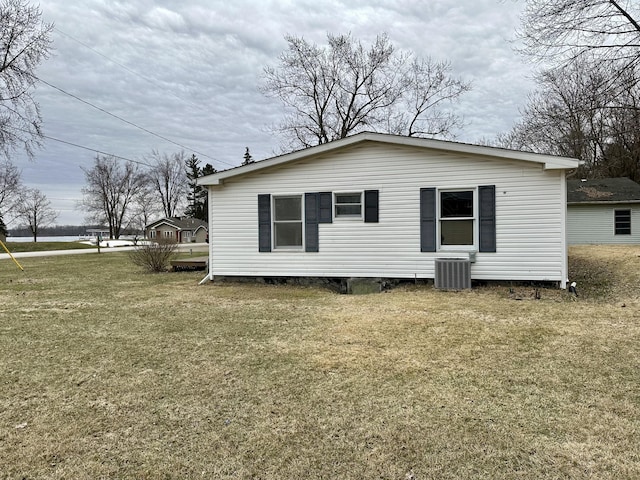 back of house featuring cooling unit and a yard