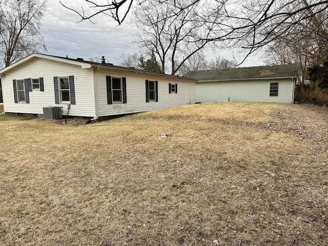 back of house featuring a lawn and central air condition unit