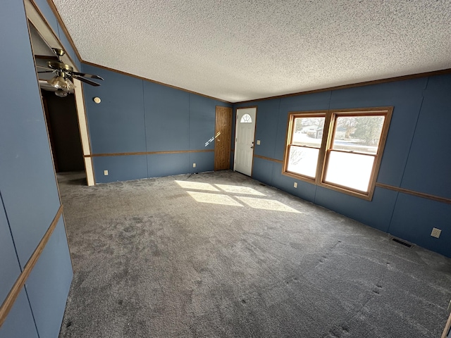 unfurnished living room with crown molding, dark carpet, and a textured ceiling