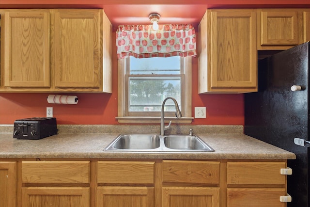 kitchen with sink and black fridge