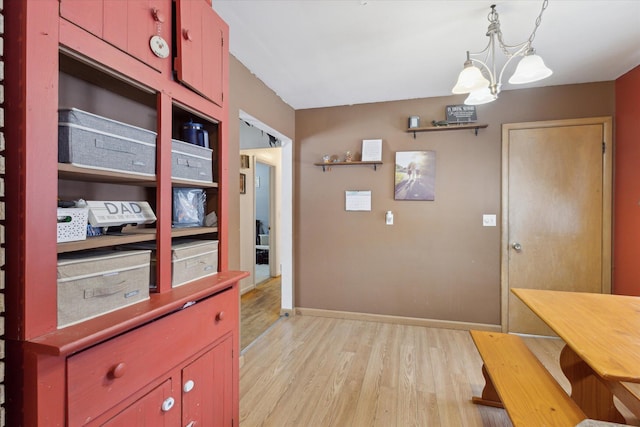 kitchen with an inviting chandelier, decorative light fixtures, and light hardwood / wood-style flooring