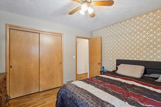 bedroom with light hardwood / wood-style floors, a closet, and ceiling fan