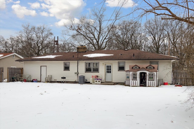 snow covered rear of property with central AC unit