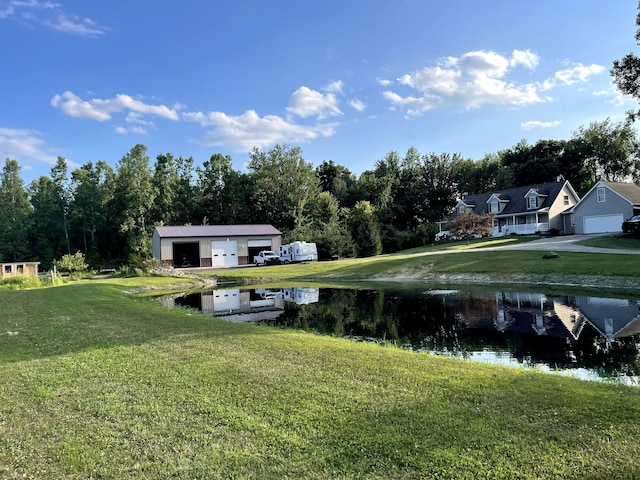 view of yard featuring a water view and a garage