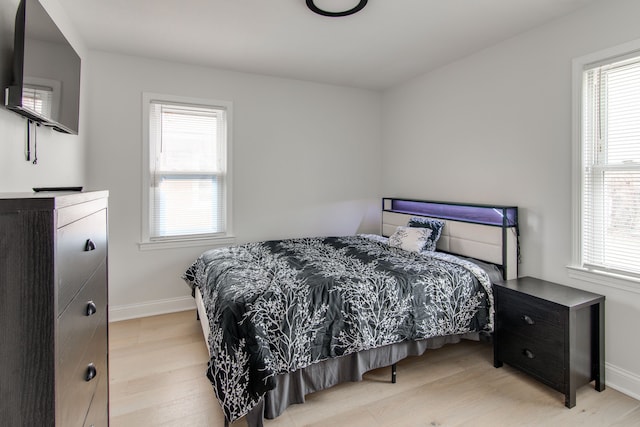 bedroom featuring multiple windows and light hardwood / wood-style flooring