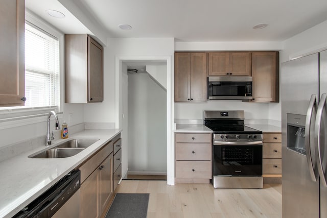 kitchen featuring stainless steel appliances, sink, and light hardwood / wood-style flooring