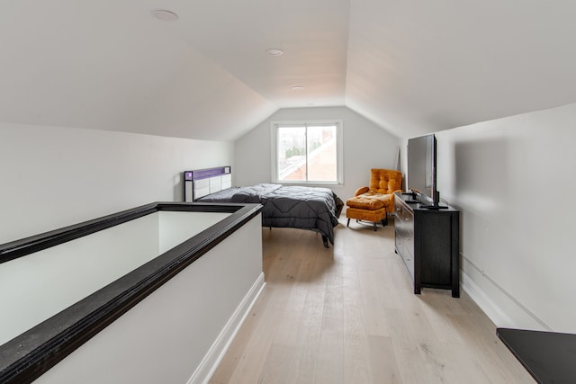 bedroom with lofted ceiling and light hardwood / wood-style flooring