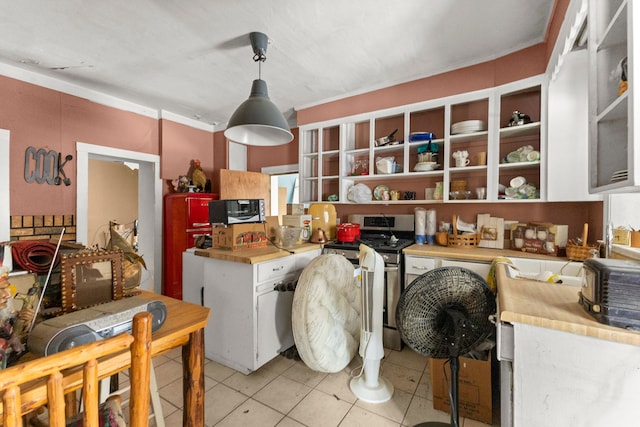 kitchen featuring white cabinetry, gas range, light tile patterned flooring, and hanging light fixtures