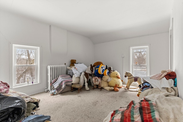 bedroom with radiator heating unit, vaulted ceiling, and carpet flooring