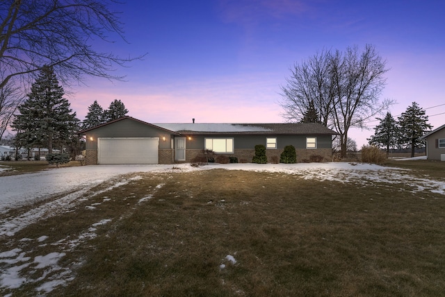 ranch-style house with a garage and a lawn