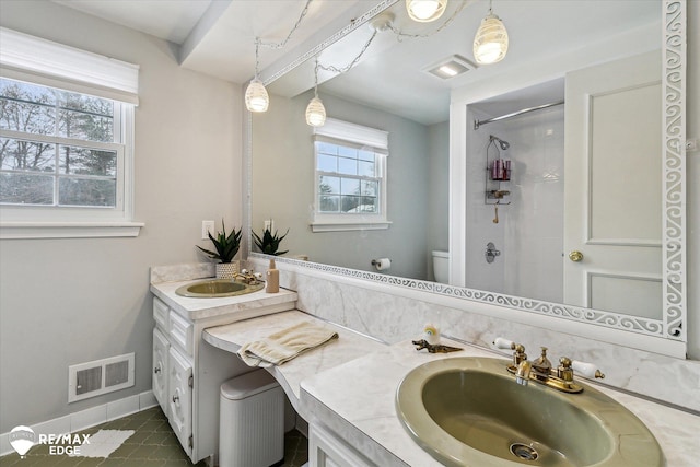 bathroom with a shower, vanity, tile patterned floors, and toilet