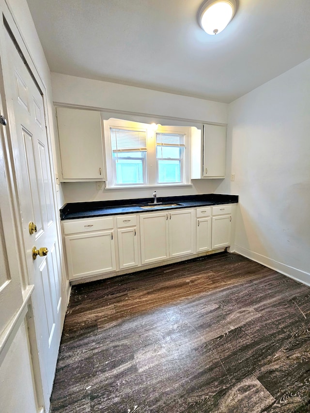 kitchen featuring dark hardwood / wood-style flooring, sink, and white cabinets