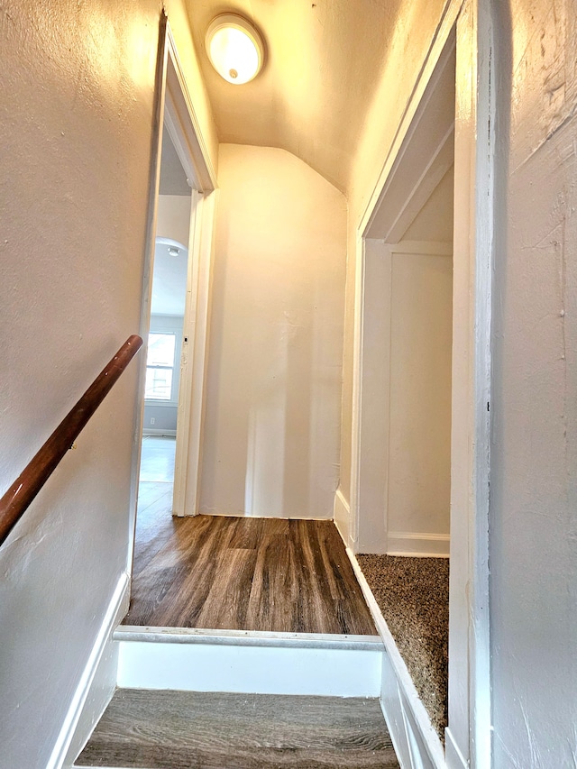 stairs with vaulted ceiling and hardwood / wood-style floors