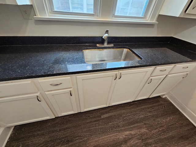 kitchen with white cabinetry, dark stone counters, dark wood-type flooring, and sink