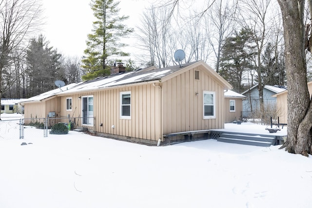 view of snow covered back of property