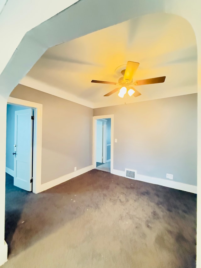 unfurnished room featuring dark colored carpet and ceiling fan