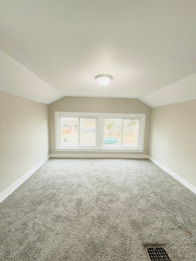 additional living space with lofted ceiling and carpet flooring