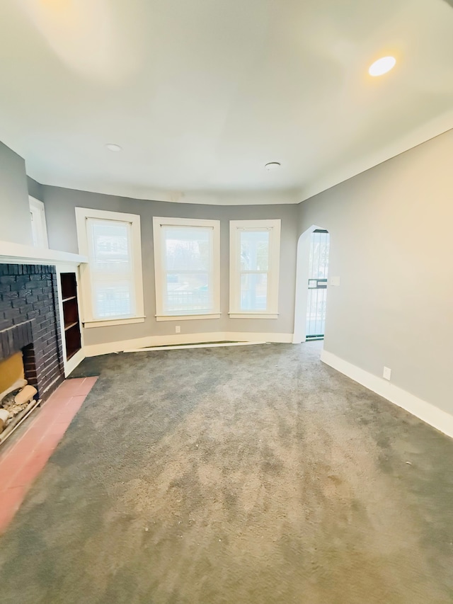 unfurnished living room with a fireplace and carpet flooring