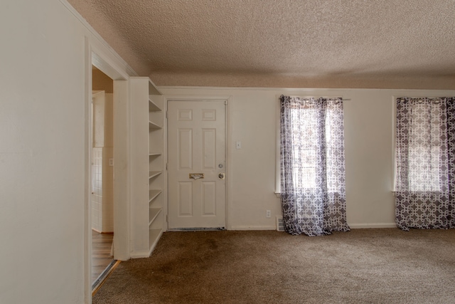 carpeted entryway featuring a textured ceiling