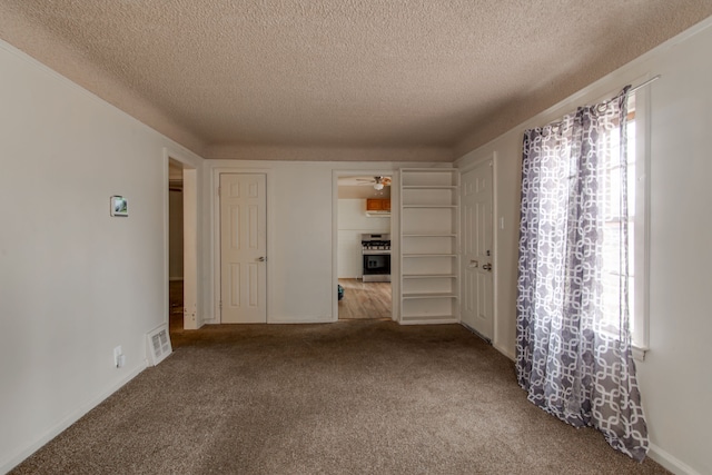 empty room with carpet floors and a textured ceiling