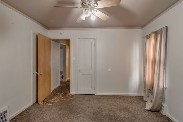 unfurnished bedroom featuring ceiling fan, ornamental molding, and carpet flooring