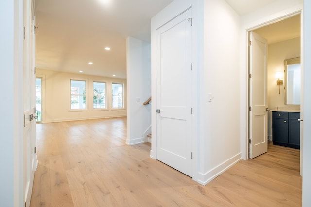 hall featuring recessed lighting, light wood-style floors, stairway, and baseboards