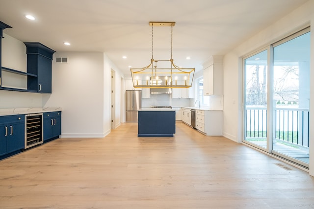 kitchen featuring light wood-style flooring, visible vents, appliances with stainless steel finishes, and wine cooler