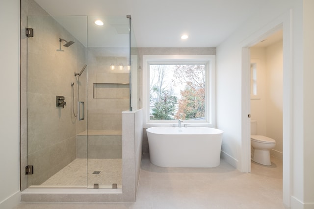 bathroom featuring toilet, a stall shower, a soaking tub, baseboards, and recessed lighting