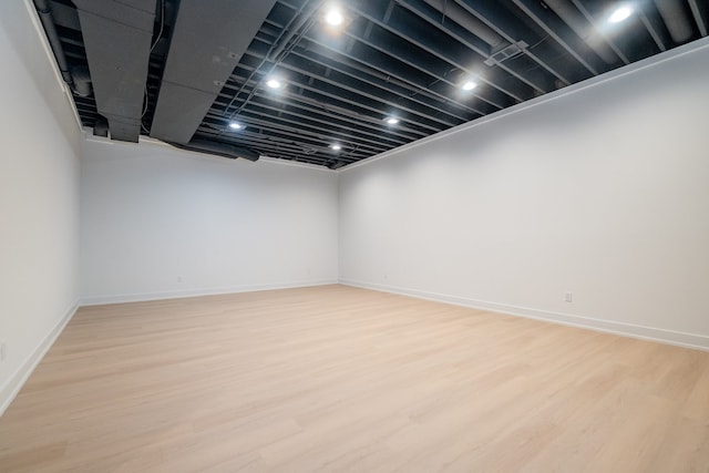 finished below grade area featuring light wood-type flooring and baseboards