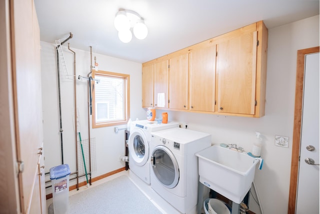 washroom featuring cabinets, sink, and washing machine and clothes dryer