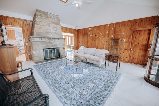 living room featuring ceiling fan, a fireplace, wooden walls, and high vaulted ceiling