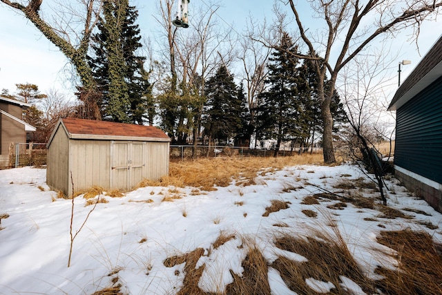 yard covered in snow with a storage shed