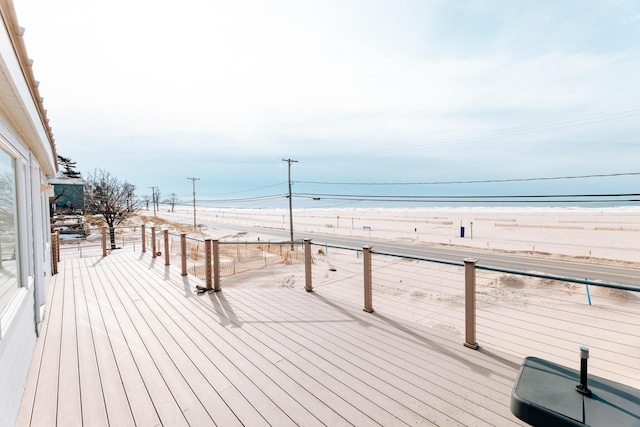 wooden terrace with a view of the beach and a water view