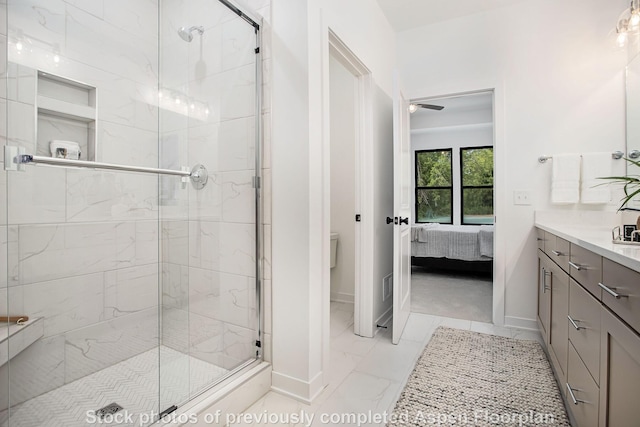 bathroom featuring vanity, a shower with door, and toilet