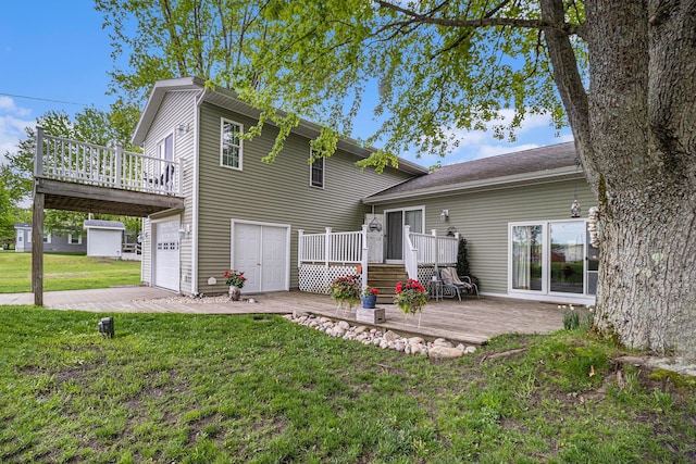 back of property with a garage, a deck, and a lawn