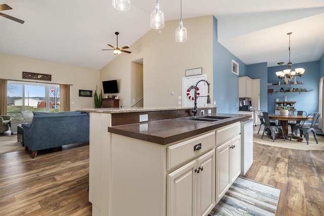 kitchen featuring sink, wood-type flooring, hanging light fixtures, a kitchen island with sink, and ceiling fan with notable chandelier