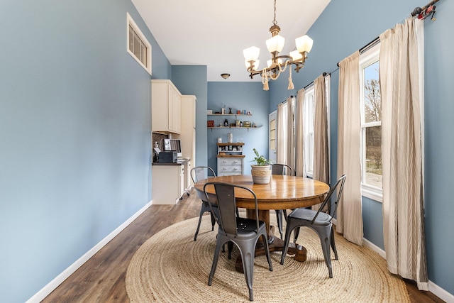 dining area featuring plenty of natural light, hardwood / wood-style floors, and a notable chandelier