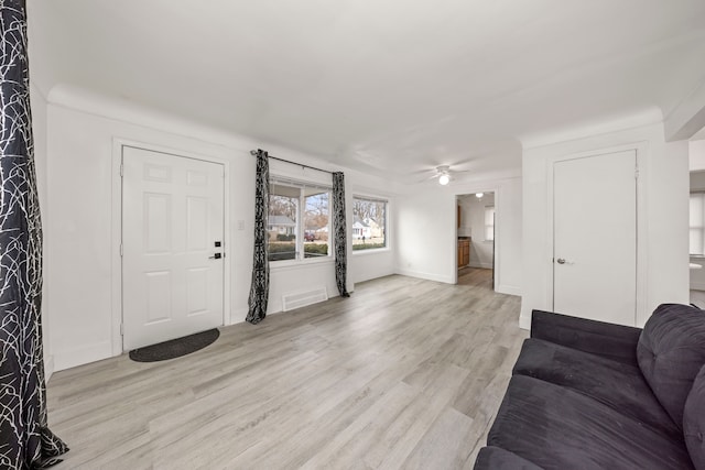 living room with light hardwood / wood-style flooring and ceiling fan