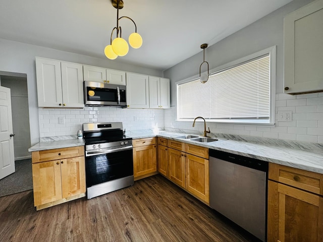 kitchen with hanging light fixtures, sink, white cabinets, and appliances with stainless steel finishes