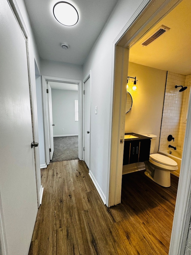 hallway with dark hardwood / wood-style flooring