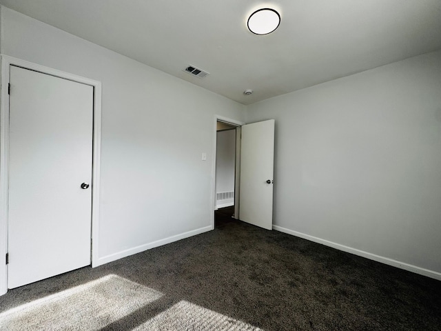 unfurnished bedroom with dark colored carpet