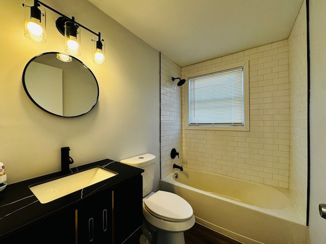 full bathroom featuring vanity, tiled shower / bath combo, and toilet