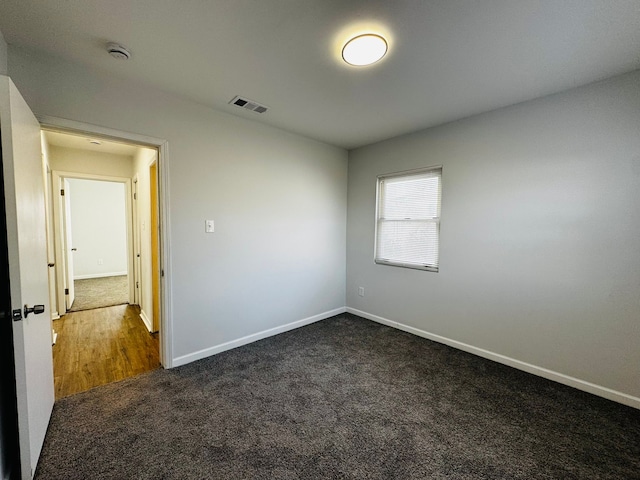 unfurnished room with dark colored carpet