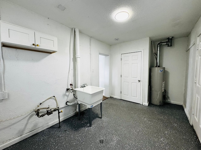 basement with sink, water heater, and a textured ceiling